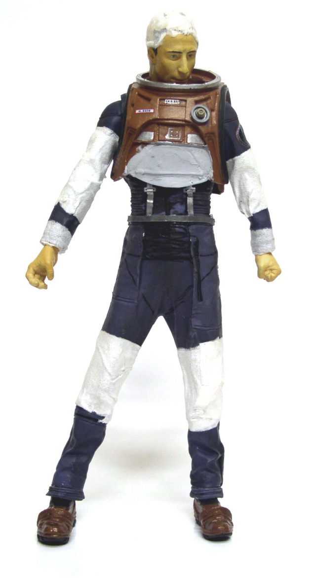 Figurine de cosmonaute en combinaison bleue et blanche avec plastron marron, vue de face