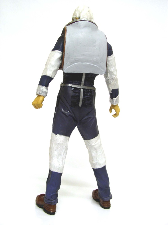 Figurine de dos d'un personnage en combinaison bleue et blanche avec sac à dos
