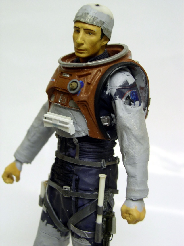 Figurine de cosmonaute en combinaison spatiale grise et plastron orange, peinture détaillée en cours