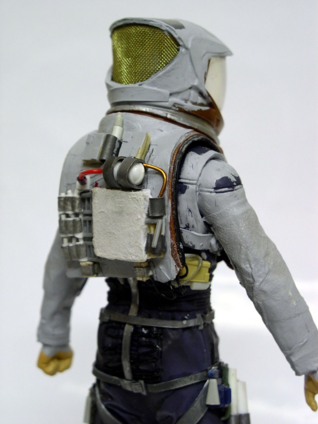 Vue de dos d'une figurine d'astronaute en scaphandre gris avec sac dorsal détaillé