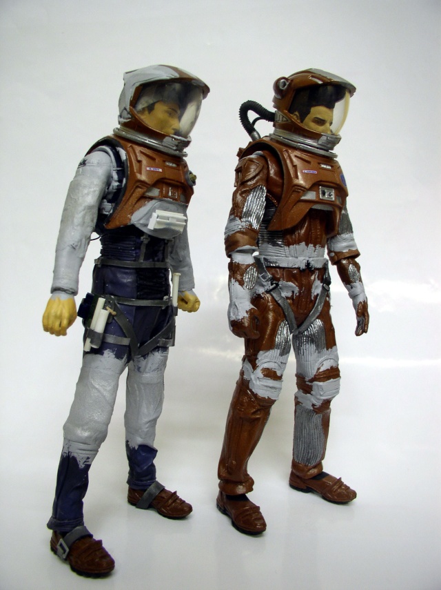 Deux figurines d'astronautes en scaphandre brun et gris à différentes étapes de peinture