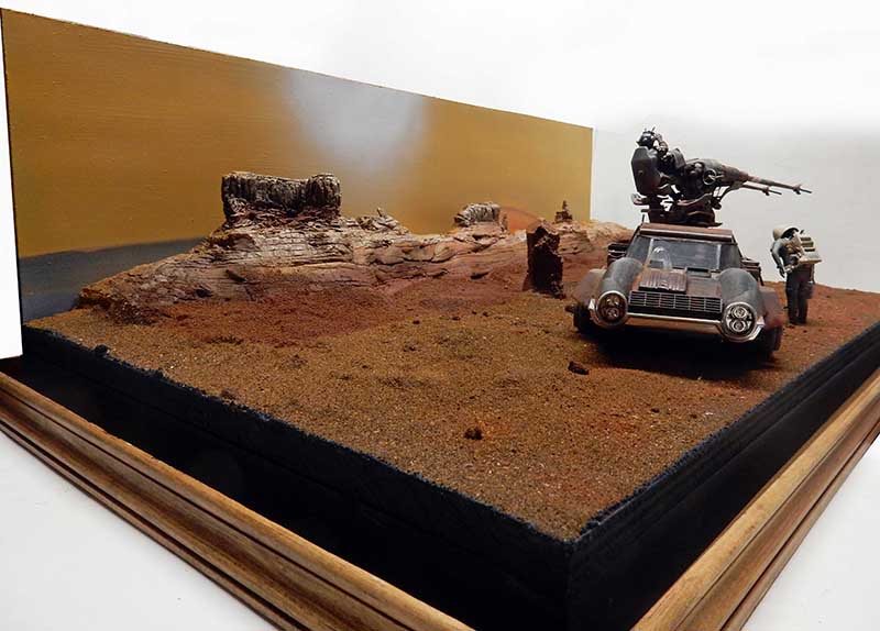 Diorama martien avec véhicule armé et figurines sur sol rougeâtre devant falaises