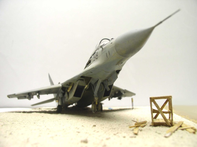 Maquette du Mig 29 Fulcrum gris vue de face sur diorama sablonneux avec caisse en bois