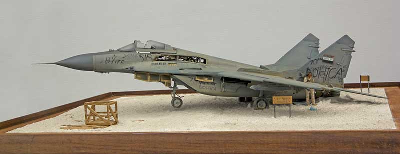 Diorama d'un Mig 29 Fulcrum abandonné et taggué sur sol sableux, avec figurine