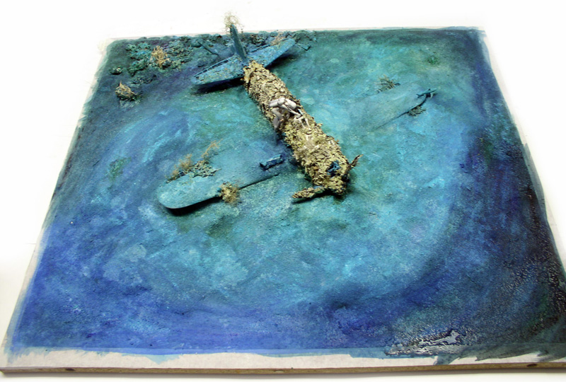 Diorama d'une épave de Mitsubishi A6M5 Zéro immergée recouverte d'algues au fond marin
