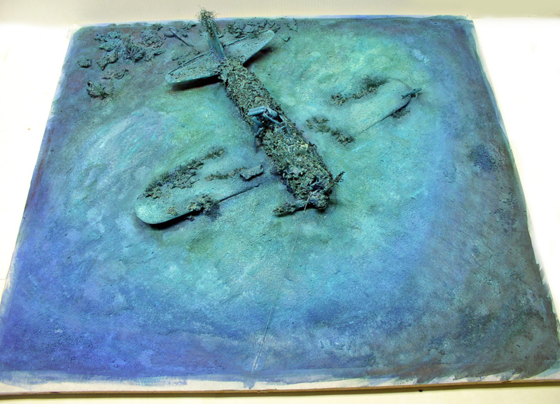 Diorama d'une épave de Mitsubishi A6M5 Zero immergée et recouverte d'algues au fond marin