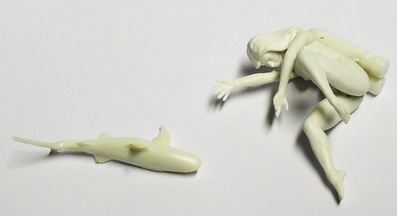 Figurines en résine non peintes représentant un requin et un personnage féminin allongé