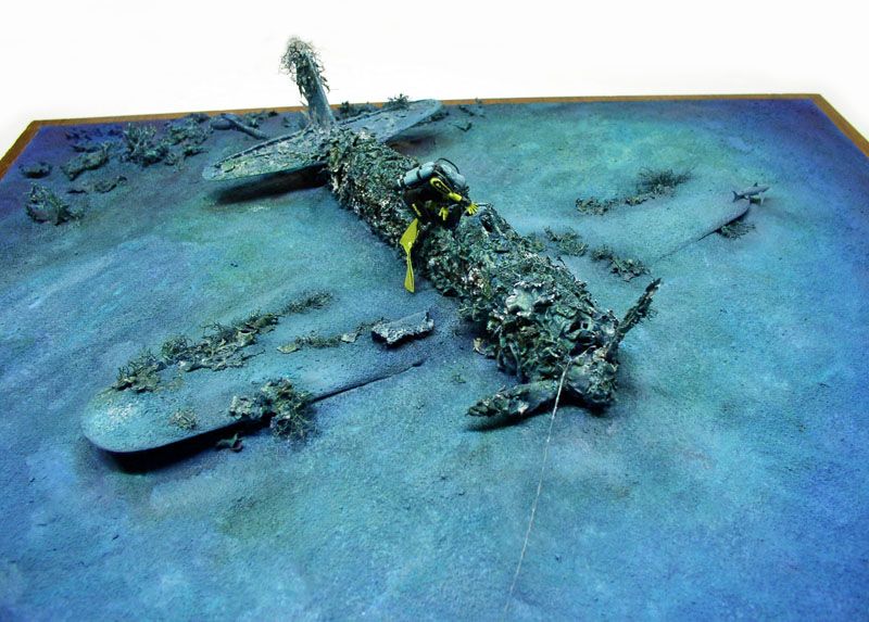 Diorama sous-marin de l'épave du Mitsubishi A6M5 explorée par un plongeur sur fond marin