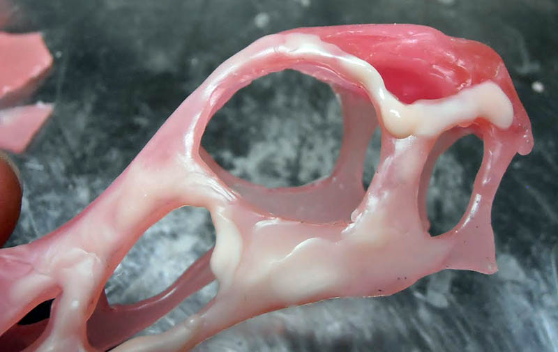 Gros plan du crâne modelé en pâte rose, orbites ajourées et ajouts de mastic blanc