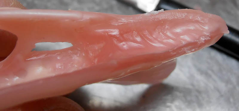 Gros plan sur le museau du crâne modelé en pâte rose, texture osseuse sculptée
