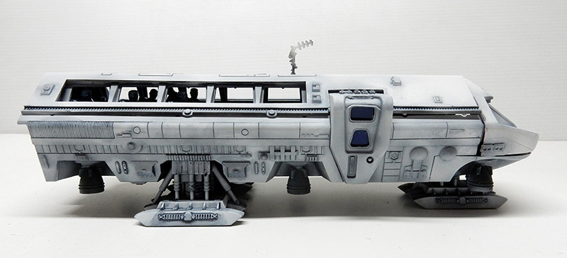 Maquette du Moonbus vue de profil, coque grise sur trains d'atterrissage avec figurines visibles par les hublots