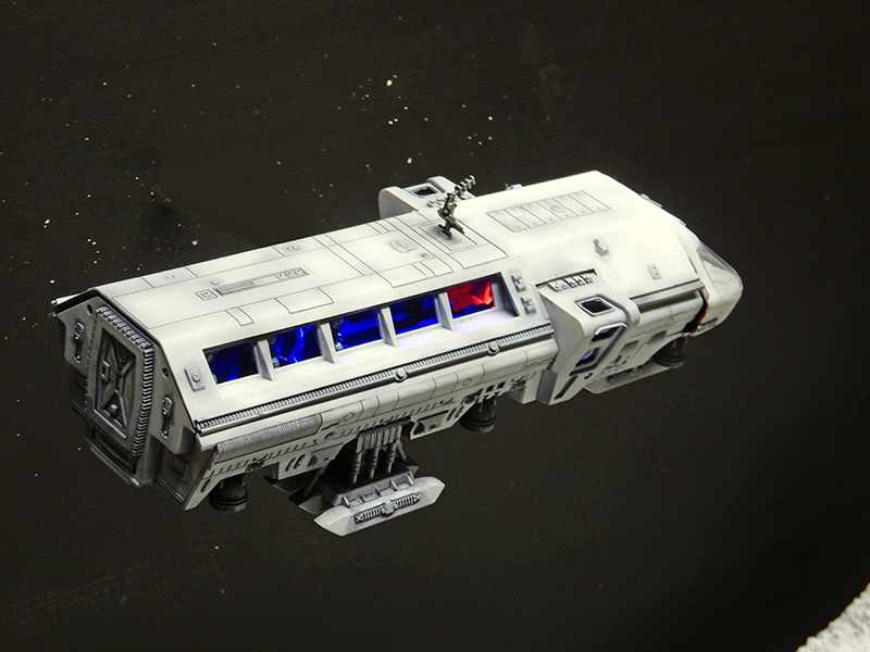 Maquette du Moonbus blanc vue de dessus avec hublots éclairés en bleu et rouge