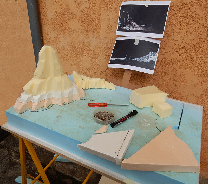 Maquette de décor lunaire en mousse sculptée avec photos de référence et outils