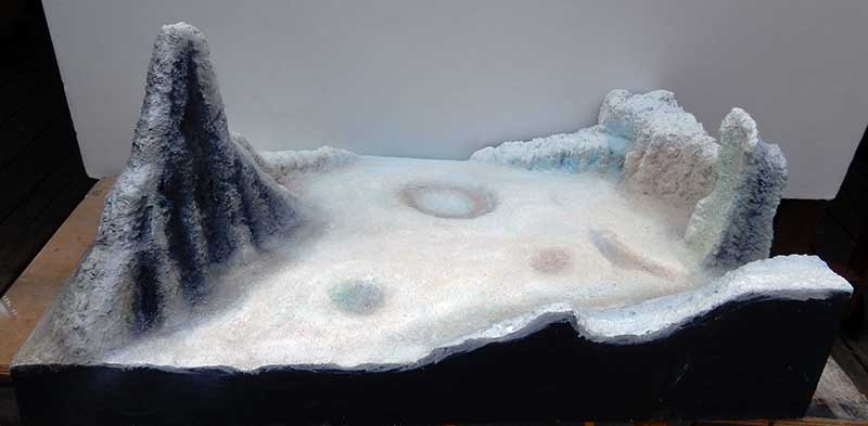 Diorama de surface lunaire avec montagnes, cratères et reliefs rocheux peints pour le Moonbus