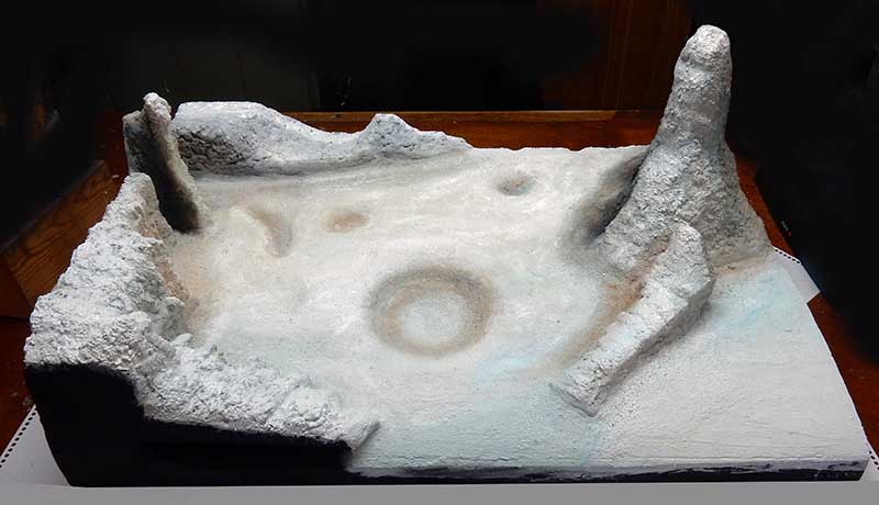 Diorama de surface lunaire blanche avec cratères et rochers pour la maquette Moonbus