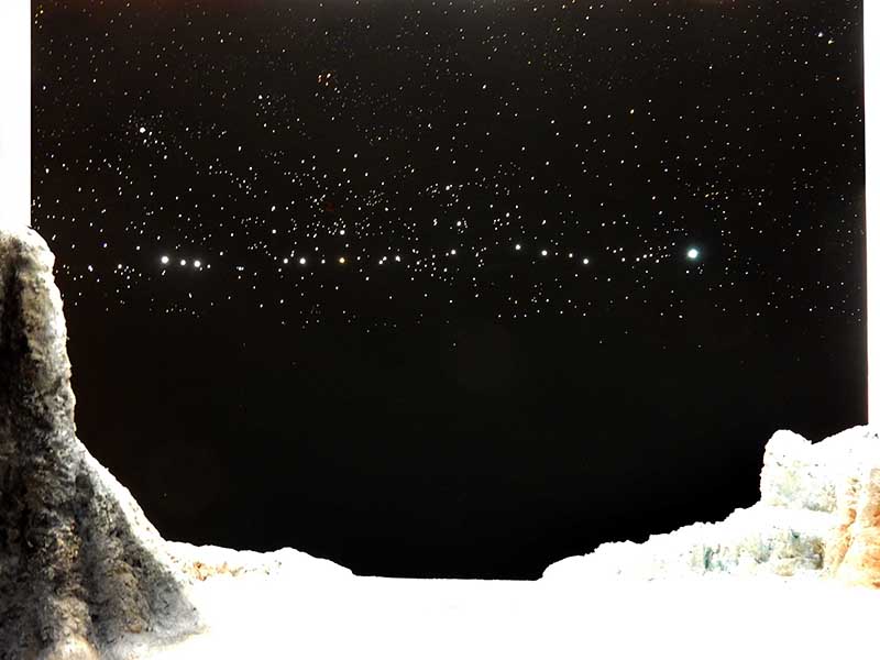 Diorama lunaire avec ciel étoilé noir et rochers blancs au premier plan