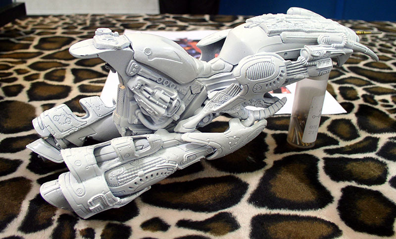 Maquette de moto volante futuriste gris apprêt en cours d'assemblage sur tissu léopard