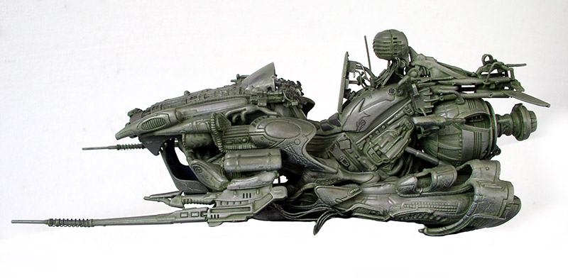 Maquette de motovolante futuriste vert-de-gris avec pilote profil, détails biomécaniques sur fond clair
