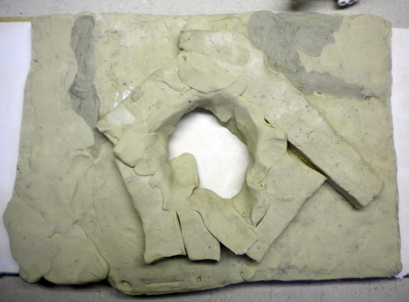 Modèle entouré de pâte à modeler avec ouverture centrale préparant le coulage du moule silicone