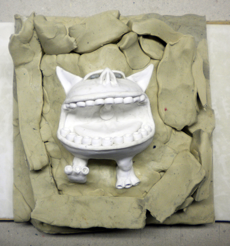Figurine blanche d'une créature souriante enserrée dans un coffrage de pâte à modeler