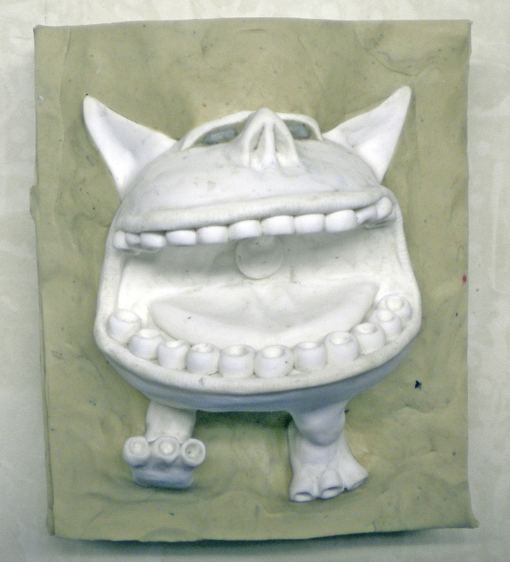 Tirage en plâtre blanc d'une créature aux grandes dents démoulé du moule silicone