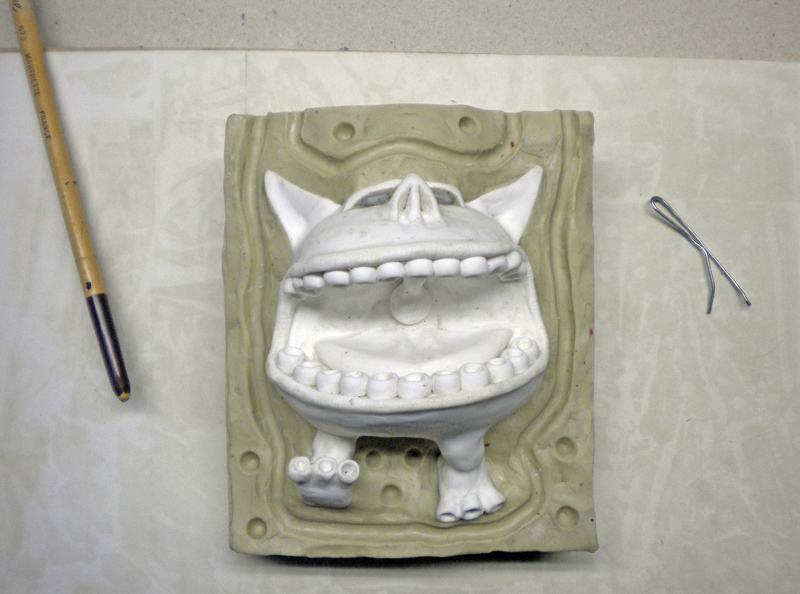 Tirage en plâtre d'une figurine grimaçante démoulé du moule souple en silicone
