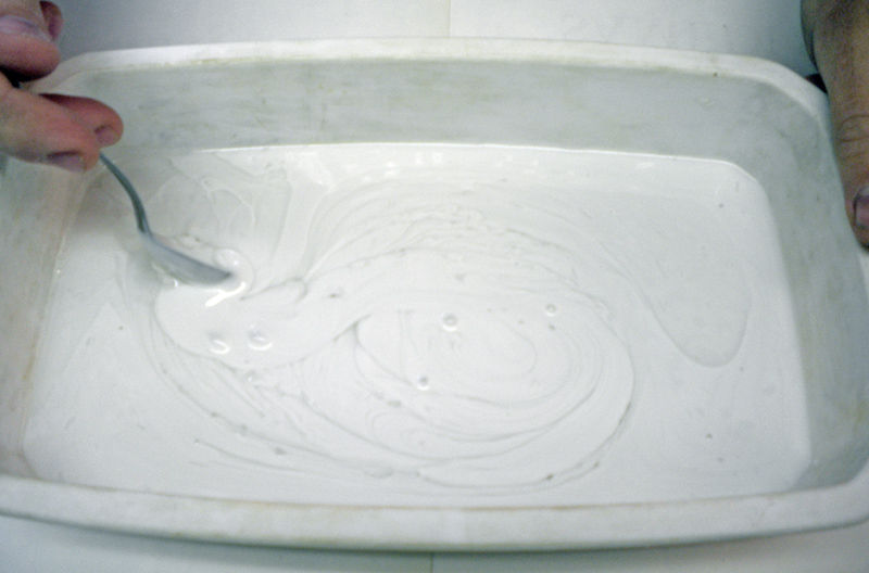 Mélange de l'élastomère de silicone blanc à la cuillère dans une barquette