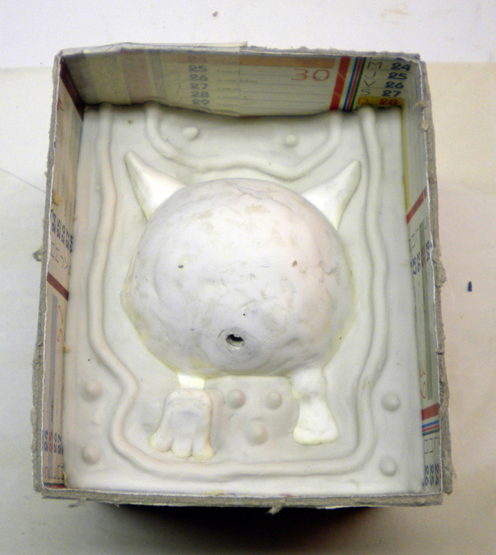 Demi-moule en silicone blanc dans un coffrage carton avec empreinte d'une figurine