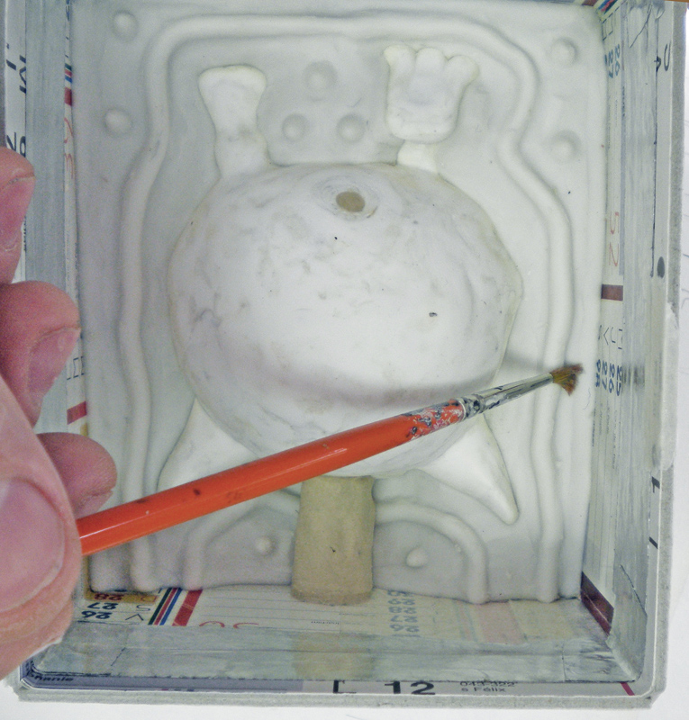 Application au pinceau d'agent démoulant sur une figurine dans un coffrage avant moulage silicone