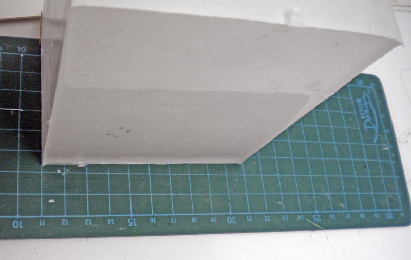 Bloc de moule souple en silicone gris posé sur un tapis de découpe vert gradué