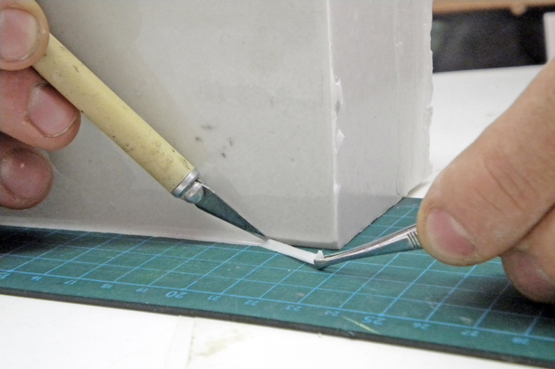 Démoulage d'un moule en silicone à l'aide d'un couteau et d'une pince
