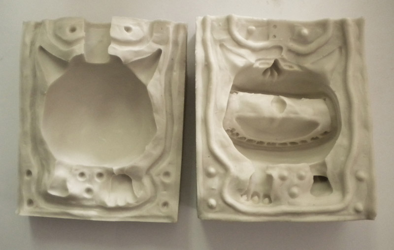 Les deux parties d'un moule en silicone blanc ouvert montrant l'empreinte d'un personnage
