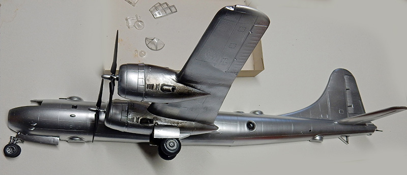 Maquette de bombardier B-29 argenté vue de profil avec pièces transparentes de verrière à côté