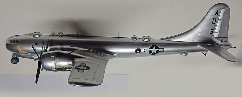 Maquette de bombardier B-29 argenté vue de profil avec nose art et insignes américains
