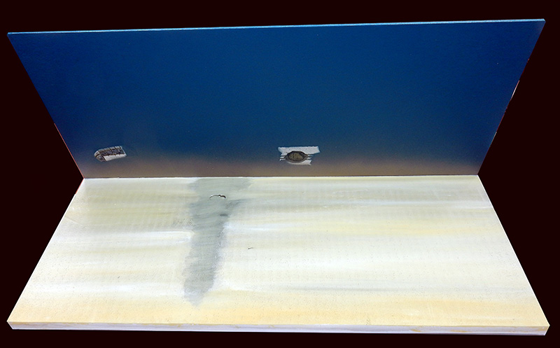 Diorama de maquette avec mur bleu dégradé et plancher clair en préparation pour Nose Art
