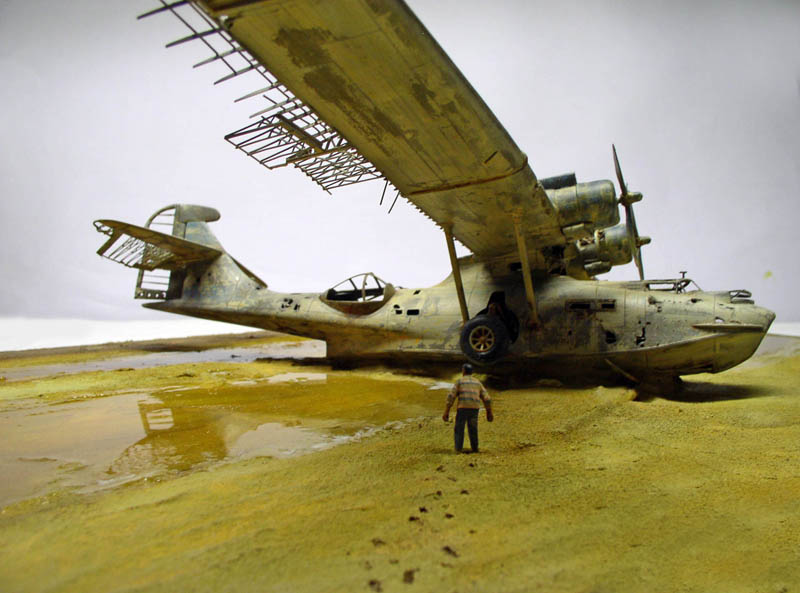 Maquette d'hydravion PBY Catalina vieilli posé sur une plage avec figurine d'homme