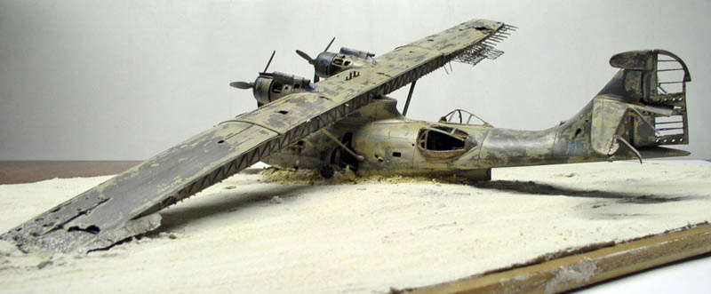 Maquette d'hydravion PBY Catalina vieilli posé sur un diorama de plage sablonneuse