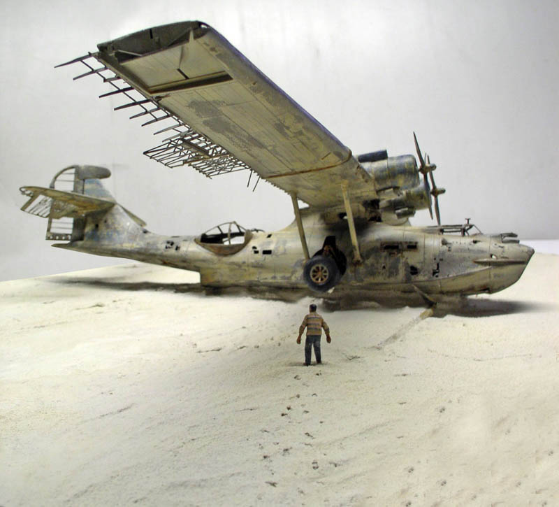 Maquette de PBY Catalina vieilli posé sur le sable avec figurine d'homme
