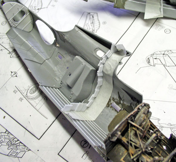 Demi-fuselage gris du PBY Catalina en cours de montage posé sur la notice