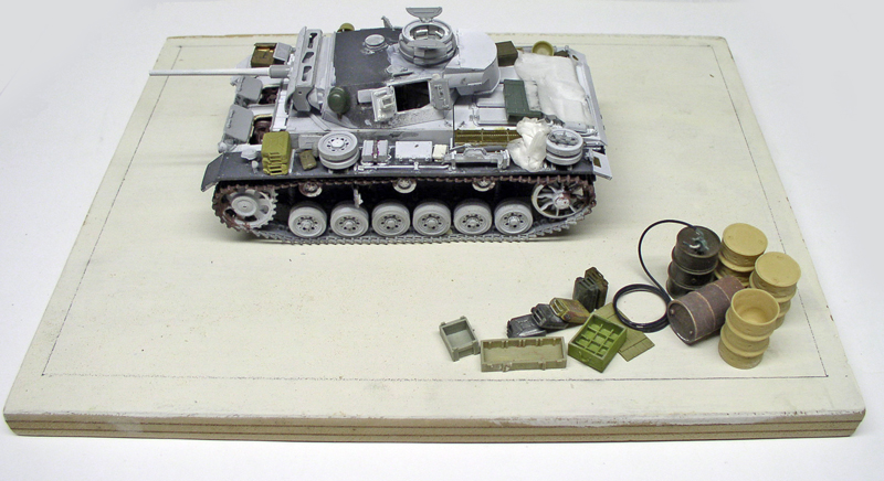 Maquette de char Panzer III en cours de montage avec accessoires sur socle blanc