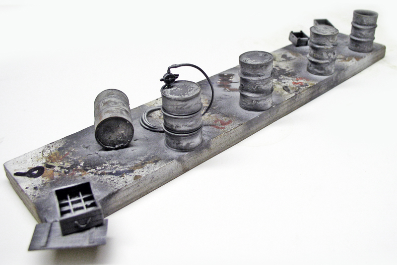 Fûts miniatures peints en noir et blanc alignés sur un socle vieilli