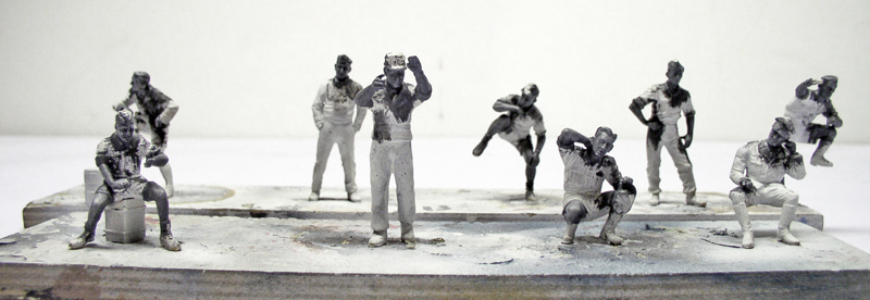 Figurines de tankistes peintes en noir et blanc disposées sur un socle de maquette