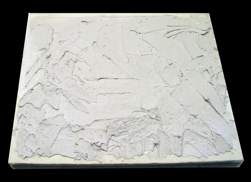Plaque de plâtre blanc étalé en relief texturé sur fond noir