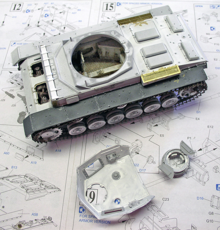 Maquette de char Panzer III en montage posée sur sa notice, châssis gris et tourelle séparée