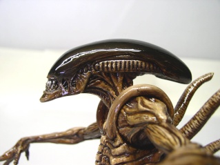 Gros plan d'une figurine d'Alien Xenomorphe peinte, mettant en valeur la tête et les dents