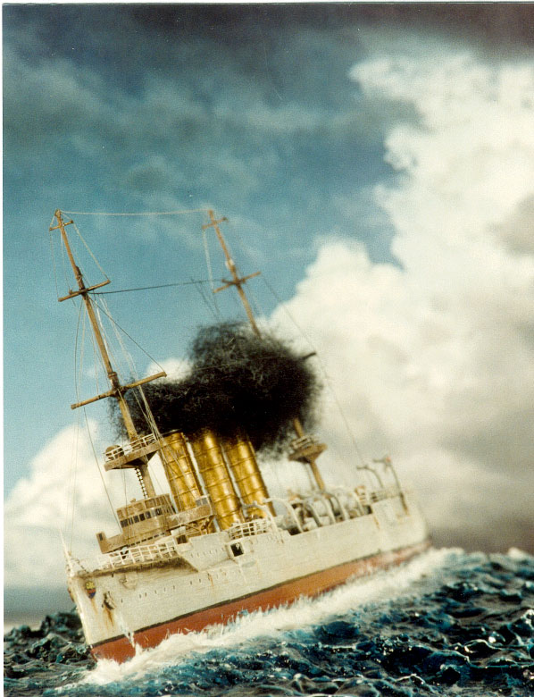 Maquette de cuirassé fendant une mer agitée, panache de fumée noire sous un ciel nuageux