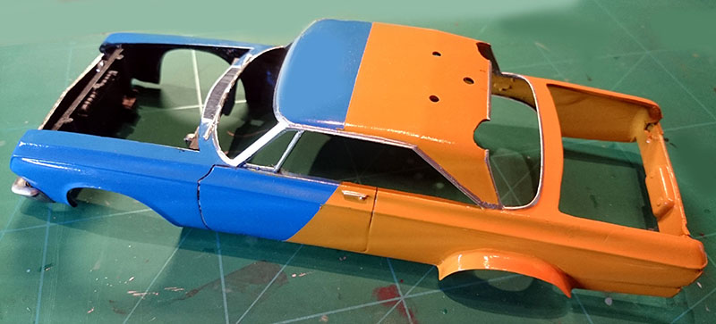 Carrosserie de la Plymouth Belvedere peinte en bleu et orange posée sur un tapis de découpe