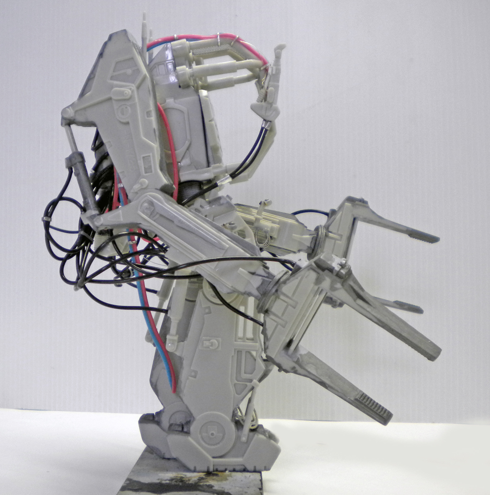 Maquette du Powerloader Aliens en montage gris avec câbles hydrauliques rouges et bleus apparents