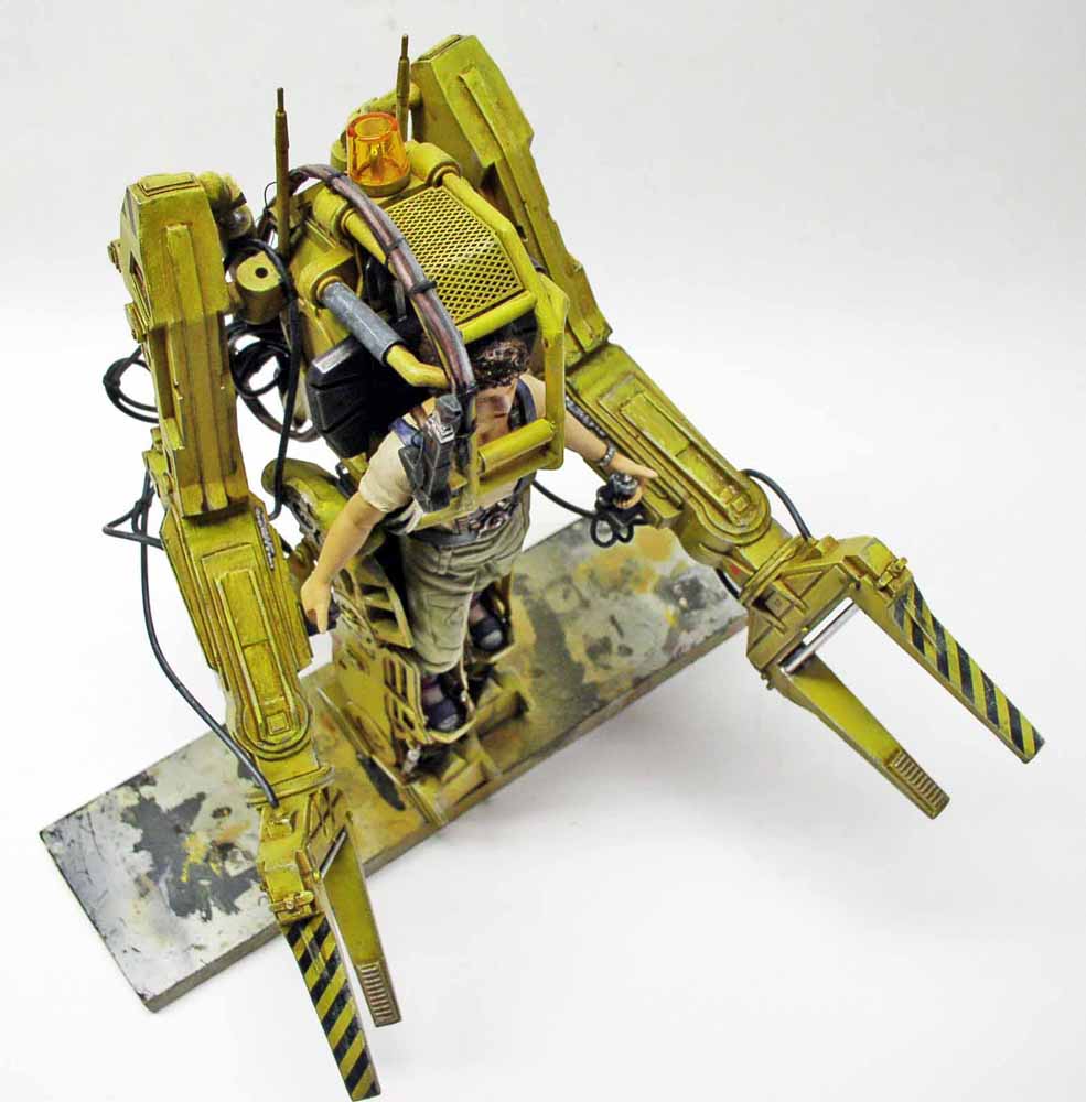 Maquette du Powerloader jaune d'Aliens avec figurine de Ripley aux commandes sur socle