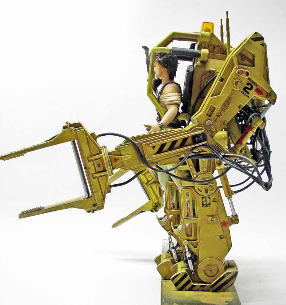 Maquette du Powerloader jaune d'Aliens avec figurine de Ripley aux commandes, vue de profil